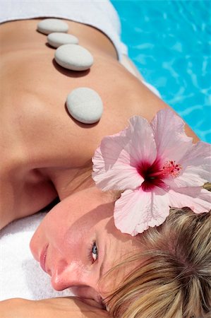 simsearch:400-05318677,k - Woman with massage stones by a blue pool Stock Photo - Budget Royalty-Free & Subscription, Code: 400-05143632