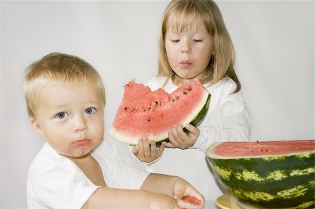 small hand big hand - Brother and sister eat Watermelon. Isolated  background. Stock Photo - Budget Royalty-Free & Subscription, Code: 400-05164702