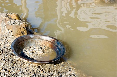 panning for gold - A well-used gold pan sits idle on the bank of a river. Stock Photo - Budget Royalty-Free & Subscription, Code: 400-05165858