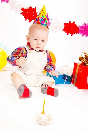 first birthday baby - Baby boy looking at the cake with one candle in it Stock Photo - Budget Royalty-Free & Subscription, Code: 400-05168828