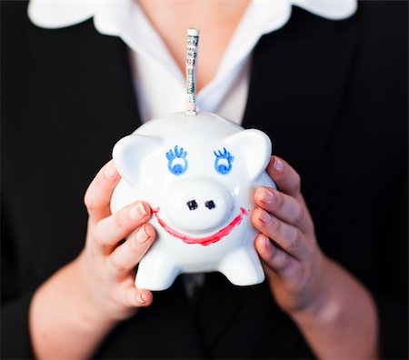 simsearch:400-05715208,k - Young Woman Holding a piggy bank with dollars in it Stock Photo - Budget Royalty-Free & Subscription, Code: 400-05162024