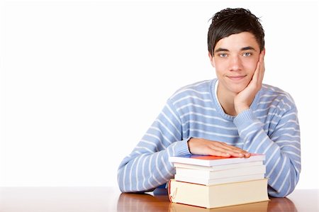 simsearch:400-04505681,k - Young student is sitting on desk with his books and smiles happy into camera. Isolated on white. Stock Photo - Budget Royalty-Free & Subscription, Code: 400-05196622