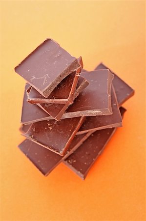 simsearch:400-05136453,k - Stack Of Dark Chocolate Pieces,  Over Orange Background Stock Photo - Budget Royalty-Free & Subscription, Code: 400-05193800