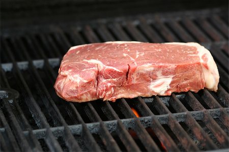 A Raw steak on a BBQ grill Stock Photo - Budget Royalty-Free & Subscription, Code: 400-05207924