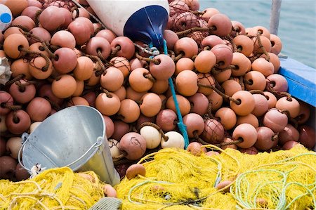 simsearch:400-05254289,k - Nylon yellow  fishing net, metal bucket, buoy close-up on the boat desk Stock Photo - Budget Royalty-Free & Subscription, Code: 400-05229655