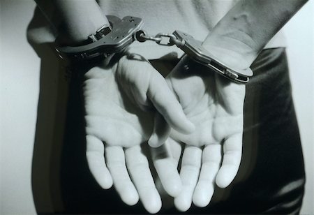 A black and white photo of woman's hands in cuffs behind her Stock Photo - Budget Royalty-Free & Subscription, Code: 400-05221944