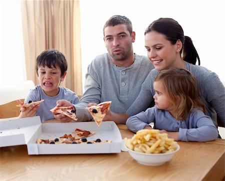 simsearch:400-04193348,k - Cheerful young family eating a pizza in the living-room at home Stock Photo - Budget Royalty-Free & Subscription, Code: 400-05234370