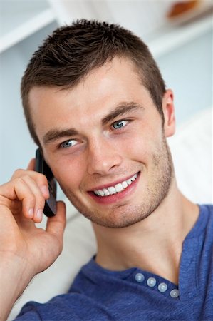 simsearch:400-04212823,k - Handsome young man talking on phone in living room Stock Photo - Budget Royalty-Free & Subscription, Code: 400-05238249