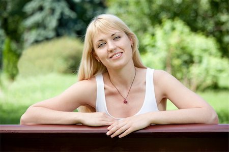 simsearch:400-04416781,k - Young Smiling optimistic cheerful blond girl 20-29 sits on the bench in summer park Stock Photo - Budget Royalty-Free & Subscription, Code: 400-05233243
