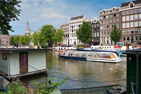 medieval amsterdam houses with their typically facades along a canal, where a tourist boat just passes by. Stock Photo - Budget Royalty-Free & Subscription, Code: 400-05247158