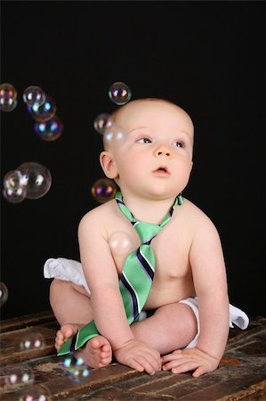 Cute baby boy sitting on an antique trunk looking at bubbles Stock Photo - Budget Royalty-Free & Subscription, Code: 400-05248999