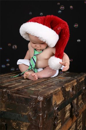 Cute christmas baby boy sitting on an antique trunk Stock Photo - Budget Royalty-Free & Subscription, Code: 400-05248993