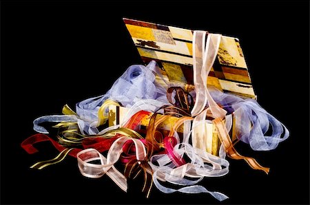 simsearch:400-04658893,k - Colorful box overflowing with beautiful ribbons on a black background Photographie de stock - Aubaine LD & Abonnement, Code: 400-05256351