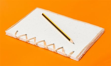 simsearch:400-04424177,k - recycled notepad and pencil over an orange background Stock Photo - Budget Royalty-Free & Subscription, Code: 400-05262194