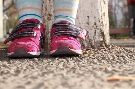 simsearch:400-04278954,k - Child in sneakers cost around a tree on the shingle Stock Photo - Budget Royalty-Free & Subscription, Code: 400-05284603