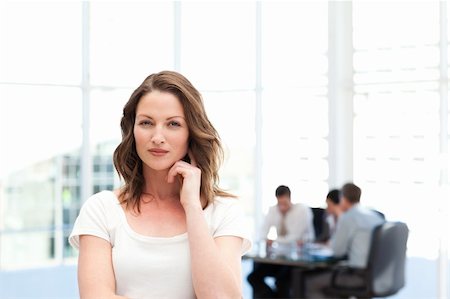 simsearch:400-05746962,k - Pensive businesswoman standing in front of her team while working in the background Stock Photo - Budget Royalty-Free & Subscription, Code: 400-05297957