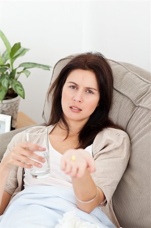 feeble - Sick woman showing a pill to the camera lying on the sofa Stock Photo - Budget Royalty-Free & Subscription, Code: 400-05298029