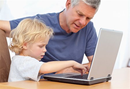 face to internet technology - Lovely boy and his grandfather looking at their laptop at home Photographie de stock - Aubaine LD & Abonnement, Code: 400-05307786