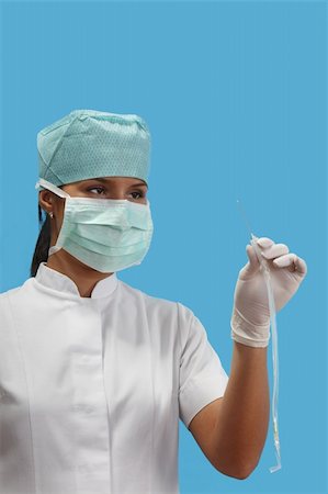 Female nurse holding an arterial catheter isolated agaisnt a blue background.Focus on the eyes. Stock Photo - Budget Royalty-Free & Subscription, Code: 400-05309187