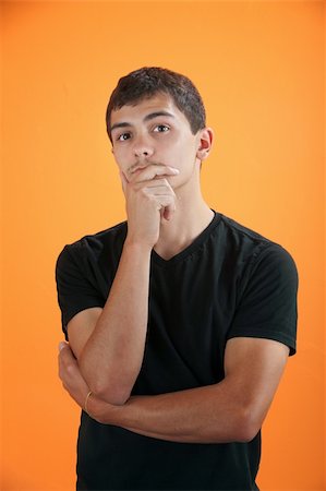 Latino teenage boy on orange background in deep thought Stock Photo - Budget Royalty-Free & Subscription, Code: 400-05315164