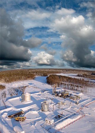 Oil and gas industry. Work of oil pump jack on a oil field.. Construction site in wild winter forest. Building of petrochemical plant. Panoramic view Stock Photo - Budget Royalty-Free & Subscription, Code: 400-05317865