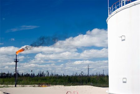 pipeline, blue sky - Oil resevoir on a petrochemical plant. Burning of gas Stock Photo - Budget Royalty-Free & Subscription, Code: 400-05317868