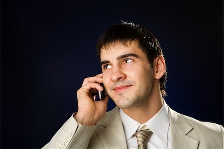 Businessman talking on cell phone over dark background Photographie de stock - Aubaine LD & Abonnement, Code: 400-05312509