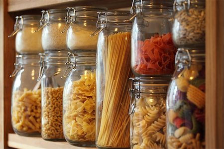 Photo of dried pasta in jars on a shelf in a domestic kitchen.  Very shallow depth of field focusing on the middle jar. Photographie de stock - Aubaine LD & Abonnement, Code: 400-05334082