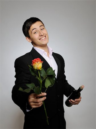 simsearch:400-04739802,k - Handsome romantic young man holding rose flower and vine bottle  prepared for a valentines day. gray background Stock Photo - Budget Royalty-Free & Subscription, Code: 400-05337203