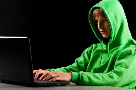 face to internet technology - hacker. Young man with laptop is looking at screen Stock Photo - Budget Royalty-Free & Subscription, Code: 400-05339153