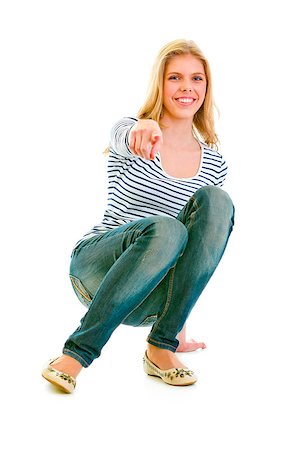 simsearch:400-05888428,k - Smiling beautiful teen girl squatting and pointing finger at you isolated on white Stock Photo - Budget Royalty-Free & Subscription, Code: 400-05339639