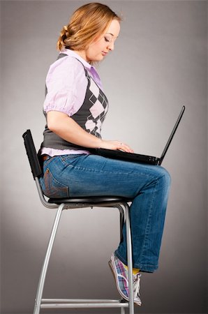 plump girls - woman is sitting on high chair and working on laptop, side view Stock Photo - Budget Royalty-Free & Subscription, Code: 400-05332885