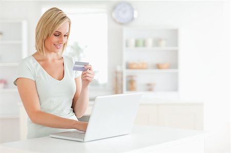 Woman with credit card and notebook in the kitchen Stock Photo - Budget Royalty-Free & Subscription, Code: 400-05345177