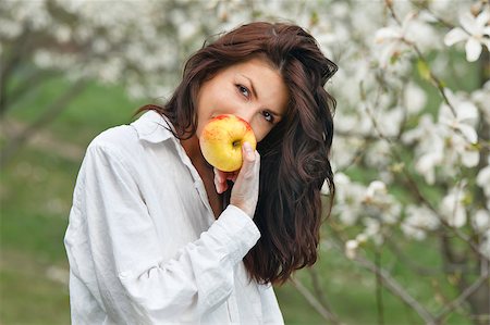 Beautiful young girl eating an apple in the park Stock Photo - Budget Royalty-Free & Subscription, Code: 400-05346922