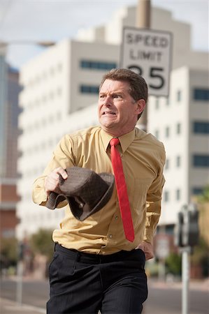 people running scared - Caucasian businessman runs on the streets to make it to meeting on time Stock Photo - Budget Royalty-Free & Subscription, Code: 400-05347564