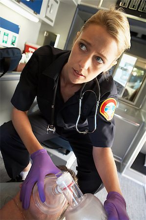 simsearch:400-05343071,k - Paramedic holding oxygen mask over patient's face Stock Photo - Budget Royalty-Free & Subscription, Code: 400-05343069