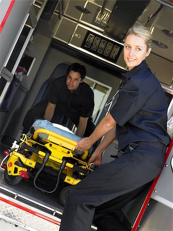 simsearch:400-05343071,k - Two paramedics cheerfully removing empty gurney from ambulance Stock Photo - Budget Royalty-Free & Subscription, Code: 400-05343087