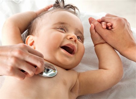 Sweet baby examined with stethoscope, holding mother's hand smiling Stock Photo - Budget Royalty-Free & Subscription, Code: 400-05356165