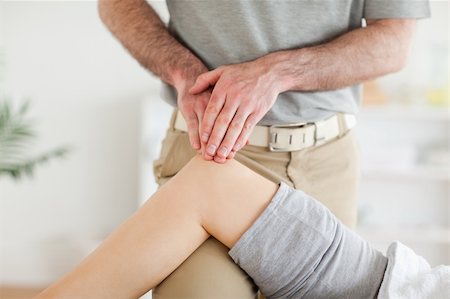 simsearch:400-05357099,k - Chiropractor massaging a cute woman's knee in a room Stock Photo - Budget Royalty-Free & Subscription, Code: 400-05357098