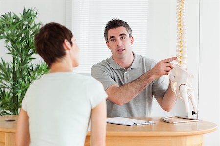 Male Doctor showing a patient a part of a spine in a room Stock Photo - Budget Royalty-Free & Subscription, Code: 400-05357275