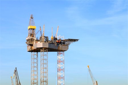 An oil rig is being constructed in a harbor area, to be towed to sea after completion. Stock Photo - Budget Royalty-Free & Subscription, Code: 400-05358052