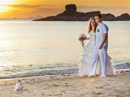 simsearch:400-05328142,k - Bride and groom walking on the beach at sunrise Stock Photo - Budget Royalty-Free & Subscription, Code: 400-05363801