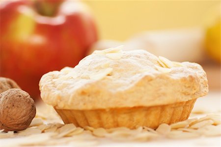 flaky - Apple pie with sprinkled peeled almonds and apple in the back Stock Photo - Budget Royalty-Free & Subscription, Code: 400-05384748