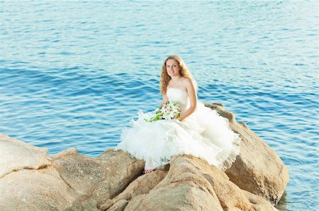 simsearch:400-05328142,k - Beautiful bride sitting on a rock in a sea Stock Photo - Budget Royalty-Free & Subscription, Code: 400-05386292