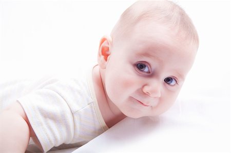 Baby boy looking at you while he lays down on white background Stock Photo - Budget Royalty-Free & Subscription, Code: 400-05387866