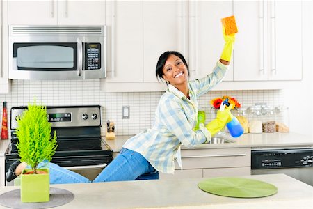 Smiling young black woman dancing and enjoying cleaning kitchen Stock Photo - Budget Royalty-Free & Subscription, Code: 400-05380300