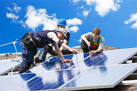 Workers installing alternative energy photovoltaic solar panels on roof Stock Photo - Budget Royalty-Free & Subscription, Code: 400-05380327