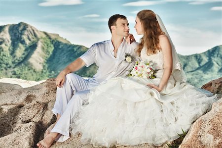 simsearch:400-05328142,k - Bride and groom sitting on the rock. Mountain on background Stock Photo - Budget Royalty-Free & Subscription, Code: 400-05381691
