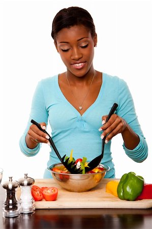 Beautiful health conscious young woman tossing healthy organic salad in kitchen, isolated. Photographie de stock - Aubaine LD & Abonnement, Code: 400-05382621