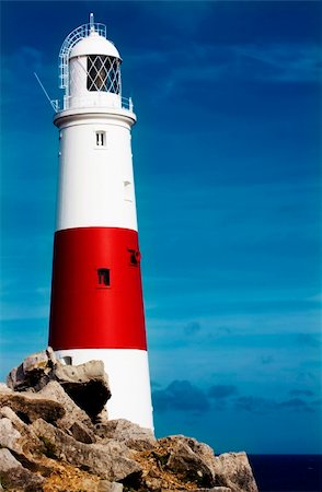 simsearch:400-04272525,k - Lighthouse on rocks looking out to sea Stock Photo - Budget Royalty-Free & Subscription, Code: 400-05668025